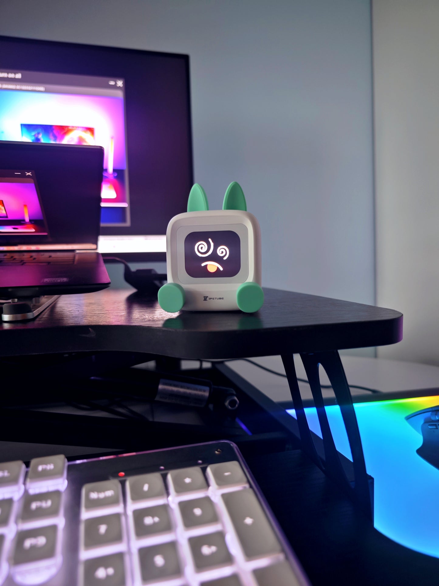 MILI Robot Pet on gaming desk setup with cyberpunk aesthetic and RGB lighting